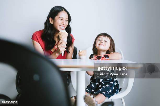 mother and daughter enjoy an ice cream cone together - filipino family eating stock pictures, royalty-free photos & images