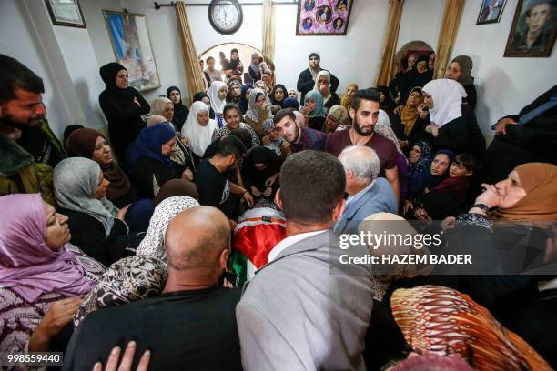 Mourners prepare to carry the body of killed Palestinian Rami Sabarneh out of his home during his funeral in the village of Beit Ummar, north of...