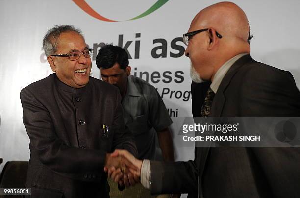 Indian Finance Minister Pranab Mukherjee shares a light moment with Group Managing Director of Pakistan's The Jung Group Shahrukh Hasan during...