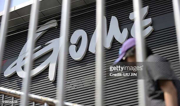 Man walks on the pedestrian bridge in front of a branch of Gome in Beijing on May 18, 2010. A Chinese court jailed Huang Guangyu, the founder of home...