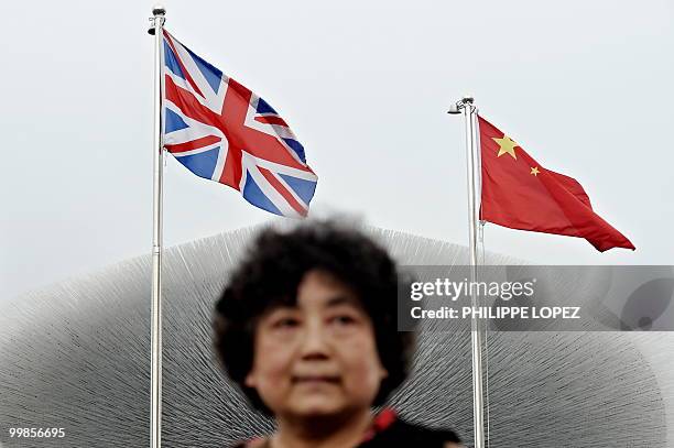 Visitor walks past the British pavilion flying the British and Chinese flags at the site of the World Expo 2010 in Shanghai on May 18, 2010....