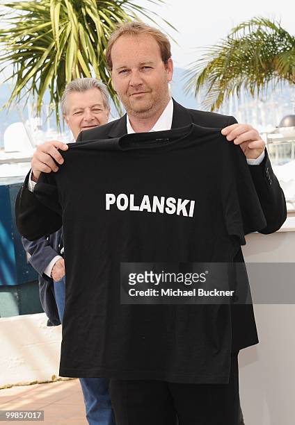 Director Xavier Beauvois holds up a t-shirt with director Roman Polanski's name on it attends the "Of Gods And Men" Photocall at the Palais des...