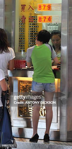 Customers change money at an currency exchange displaying Yuan to Hong Kong dollar exchange rates , in Hong Kong om May 18, 2010. China defended...