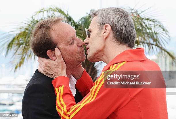 Director Xavier Beauvois receives a kiss from actor Lambert Wilson at the "Of Gods And Men" Photocall at the Palais des Festivals during the 63rd...