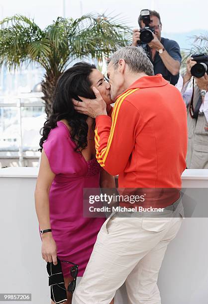 Actress Sabrina Ouzani receives a kiss from actor Lambert Wilson at the "Of Gods And Men" Photocall at the Palais des Festivals during the 63rd...