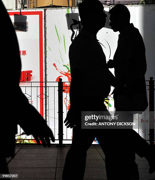 Pedestrians walk on an overpass in Hong Kong on May 18, 2010. According to the latest labour force statistics released by the Census and Statistics...