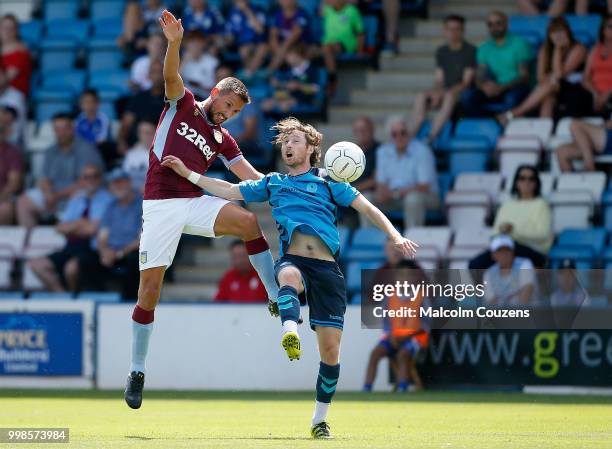 Conor Hourihane of Aston Villa competes with James McQuilkin of AFC Telford United during the Pre-season friendly between AFC Telford United and...