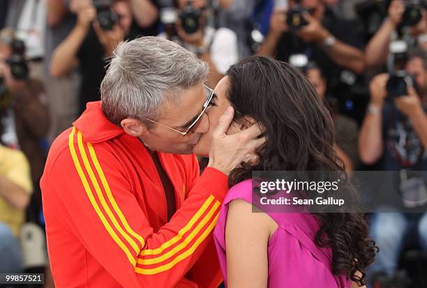 Actress Sabrina Ouzani receives a kiss from actor Lambert Wilson at the "Of Gods And Men" Photocall at the Palais des Festivals during the 63rd...