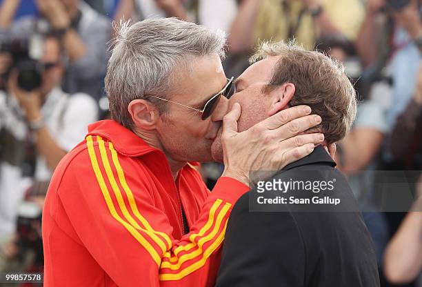 Director Xavier Beauvois receives a kiss from actor Lambert Wilson at the "Of Gods And Men" Photocall at the Palais des Festivals during the 63rd...