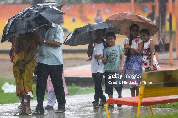 Children enjoy the rain at Prabhadevi, on July 13, 2018 in Mumbai, India. Heavy rains made a comeback in Mumbai causing waterlogging in many parts of...