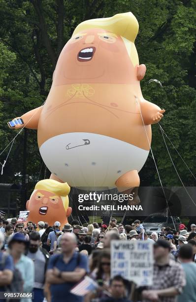 Giant balloons depicting US President Donald Trump as an orange baby are launched in the Meadows, after protesters take part in the Scotland United...