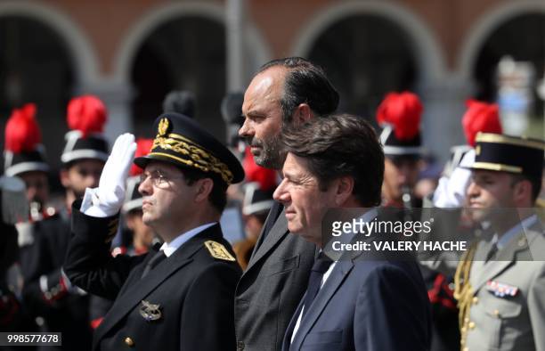 French Prime Minister Edouard Philippe stands with Mayor of Nice Christian Estrosi as he reviews an honour guard of troops in Nice on July 14 during...