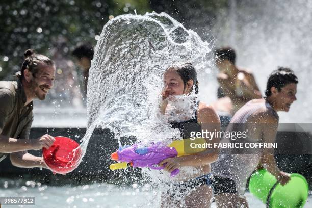 Participants throw water during a flash mob in the fountain of the "Parc de Milan" public park on July 14, 2018 in Lausanne.