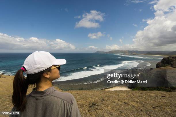 a young indonesian women enjoy the view after a short trek on the marese hill by tanjung aan in kuta in south lombok in indonesia, southeast asia - didier marti stock pictures, royalty-free photos & images