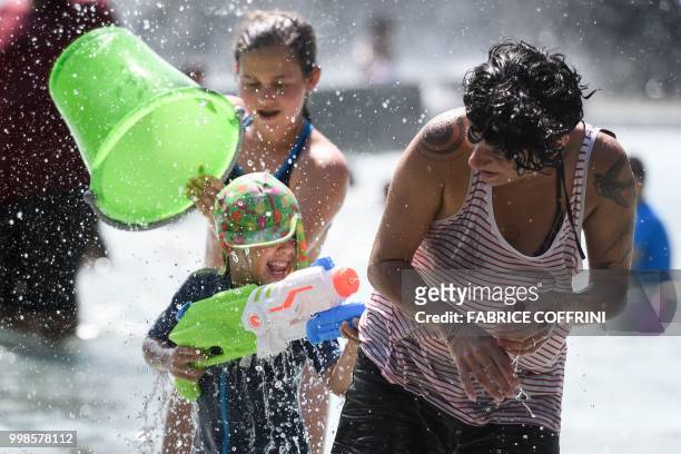 Participants throw water during a flash mob in the fountain of the "Parc de Milan" public park on July 14, 2018 in Lausanne.