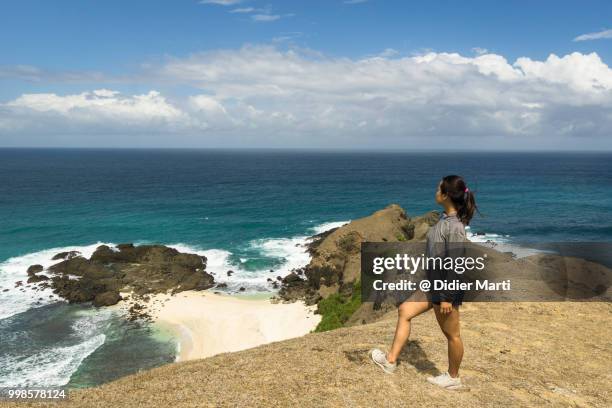 a young indonesian women enjoy the view after a short trek on the marese hill by tanjung aan in kuta in south lombok in indonesia, southeast asia - didier marti stock pictures, royalty-free photos & images