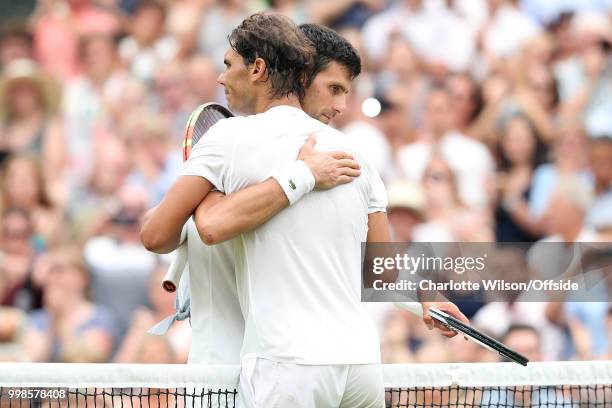 Mens Singles, Semi-Final - Rafael Nadal v Novak Djokovic - Novak Djokovic hugs Rafael Nadal over the net after winning at All England Lawn Tennis and...