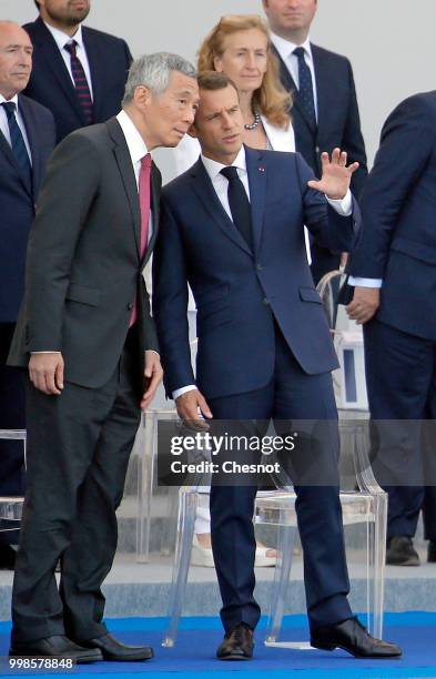 French President Emmanuel Macron and Singapore's Prime Minister Lee Hsien Loong attend the traditional Bastille Day military parade on the...