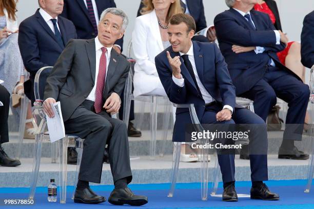 French President Emmanuel Macron and Singapore's Prime Minister Lee Hsien Loong attend the traditional Bastille Day military parade on the...