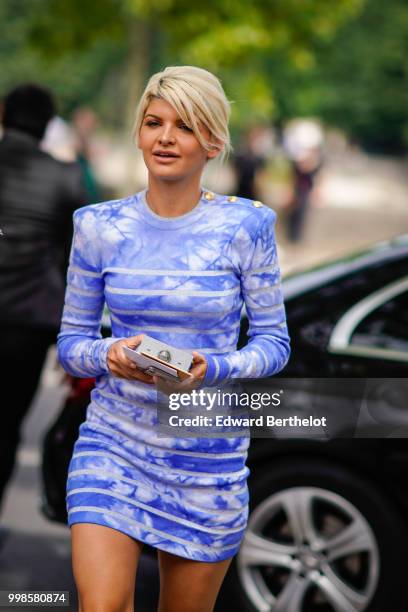 Guest wears a blue and white dress, outside Balmain, during Paris Fashion Week - Menswear Spring-Summer 2019, on June 24, 2018 in Paris, France.