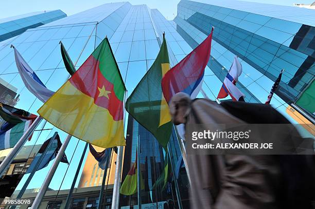 South Africans walking to work in Johannesburg on May 17, 2010 pass a building with the flags of the 32 countries competing in the Fifa World Cup...