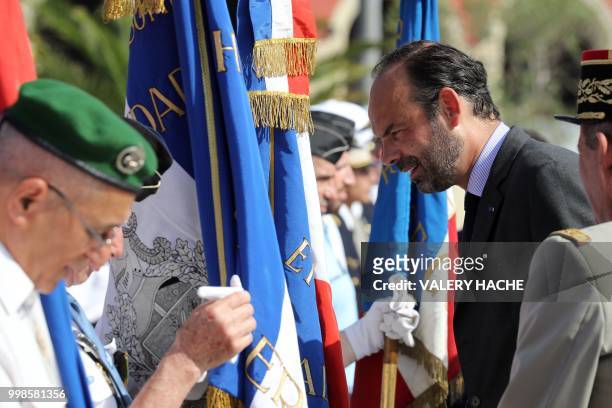 French Prime Minister Edouard Philippe talks to a veteran in Nice on July 14 during a ceremony for the second anniversary of attacks on the French...