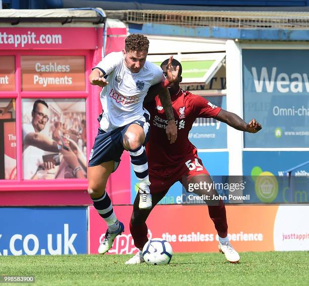 Sheyi Ojo of Liverpool competes with Callum McFadzean of Bury during the Pre-Season friendly match between Bury and Liverpool at Gigg Lane on July...