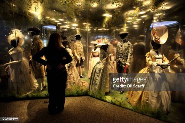 Woman admires a collection of 18th Century dresses and Philip Treacy hats new 'Galleries of Modern London' exhibition in the Museum of London on May...