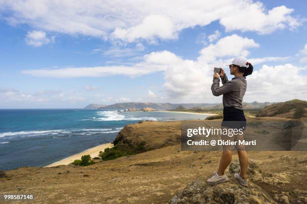 a young indonesian women enjoy the view after a short trek on the marese hill by tanjung aan in kuta in south lombok in indonesia, southeast asia - lombok stock-fotos und bilder