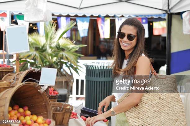 a young ethnic woman shopping at the farmers market on a warm sunny day - mireya acierto stockfoto's en -beelden