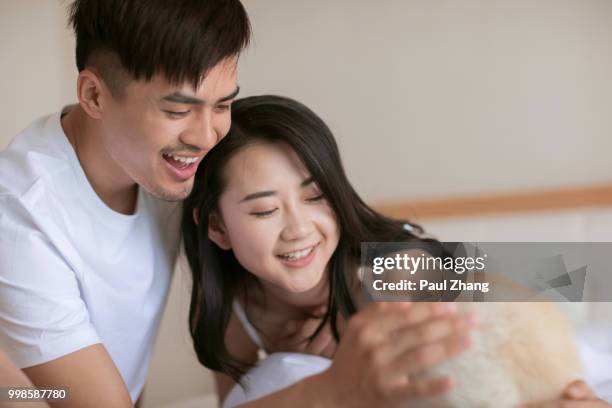 young couple in bedroom with pet dog - akita inu fotografías e imágenes de stock