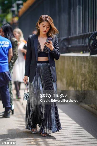 Guest wears a lace mesh pleated skirt, a blazer jacket, black lace bras, outside Balmain, during Paris Fashion Week - Menswear Spring-Summer 2019, on...