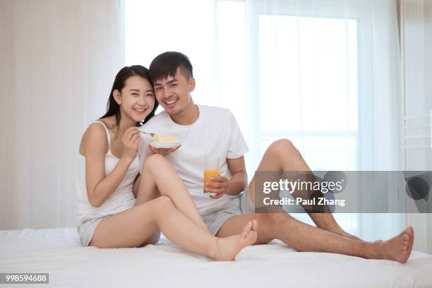 young couple sitting on the bed - couple portrait soft ストックフォトと画像