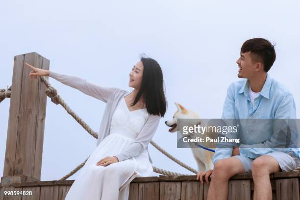 young couple at the pier - akita inu fotografías e imágenes de stock