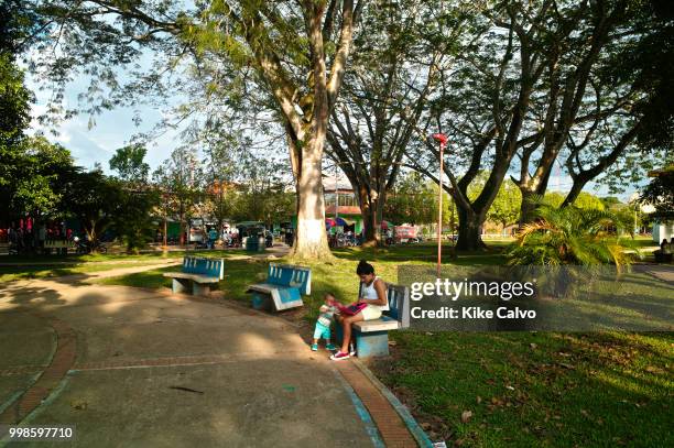 Mother taking care of her toddler, checking her email using a laptop and connecting using a public wifi connection in La Macarena's main square.