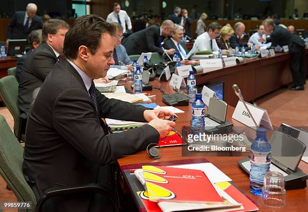 George Papaconstantinou, Greece's finance minister, examines his mobile phone during the meeting of European Union finance ministers in Brussels,...