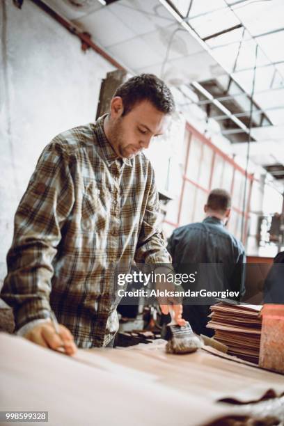 carpenter apprentice putting glue to furniture parts - aleksandar georgiev stock pictures, royalty-free photos & images