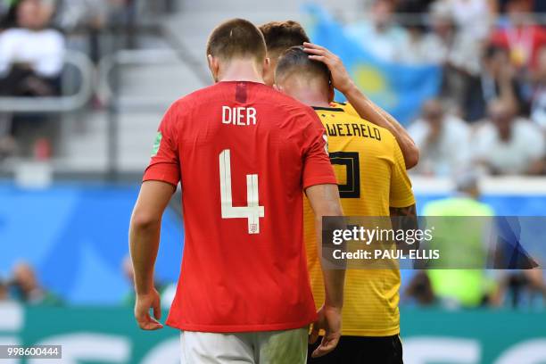 Belgium's defender Thomas Meunier thanks Belgium's defender Toby Alderweireld for clearing a shot by England's midfielder Eric Dier during their...