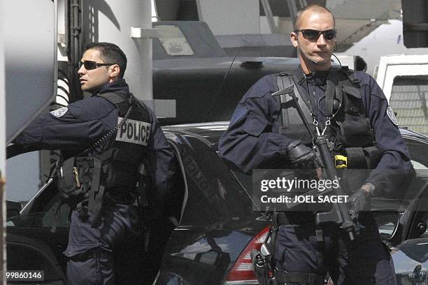Policemen surround on the Orly aiport tarmac, near Paris, the car which carried Iranian agent Ali Vakili Rad, on May 18, 2010 after his release from...
