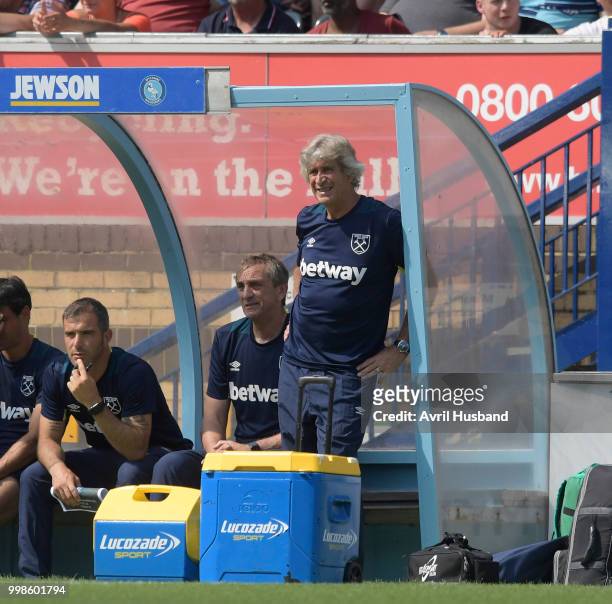 Manuel Pellegrini of West Ham United watches on from the dugout during the pre season friendly between Wycombe Wanderers and West Ham United at Adams...