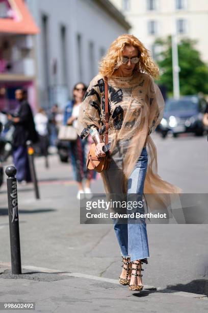 Elina Halimi wears a beige mesh top, flared jeans, outside Lanvin, during Paris Fashion Week - Menswear Spring-Summer 2019, on June 24, 2018 in...