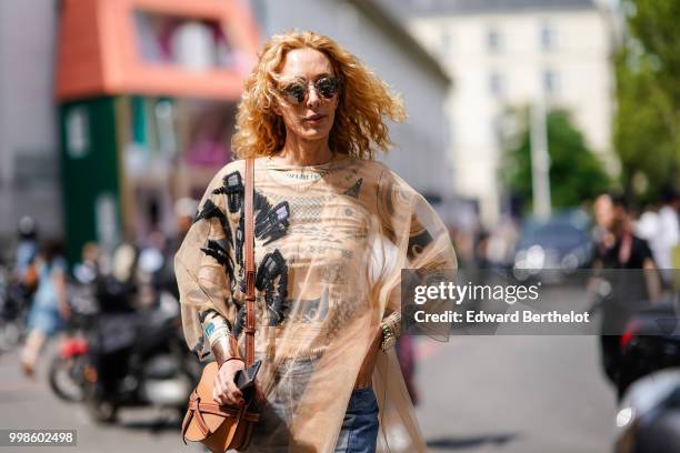 Elina Halimi wears a beige mesh top, flared jeans, outside Lanvin, during Paris Fashion Week - Menswear Spring-Summer 2019, on June 24, 2018 in...