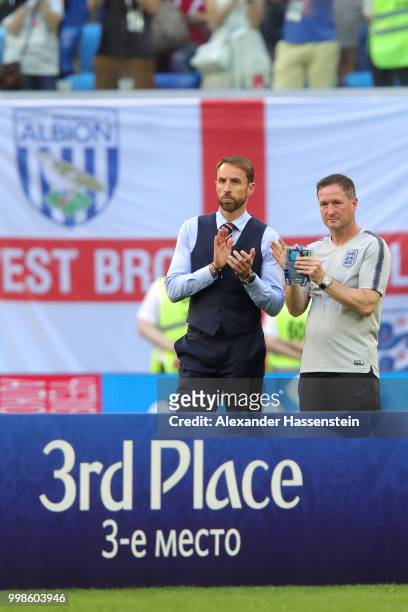 Gareth Southgate, Manager of England and England assistant manager, Steve Holland applaud Belgium as they recieve their third place medal after the...