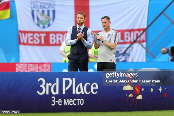 Gareth Southgate, Manager of England and England assistant manager, Steve Holland applaud Belgium as they recieve their third place medal after the...