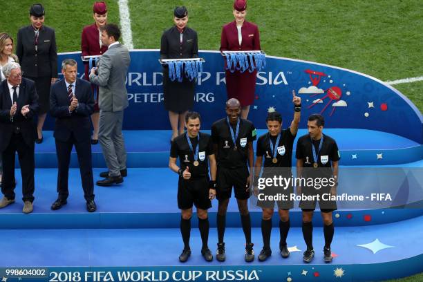 Assistant referee Mohammadreza Mansouri, Fourth official Malang Diedhiou, Referee Alireza Faghani and Assistant referee Reza Sokhandan are awarded...