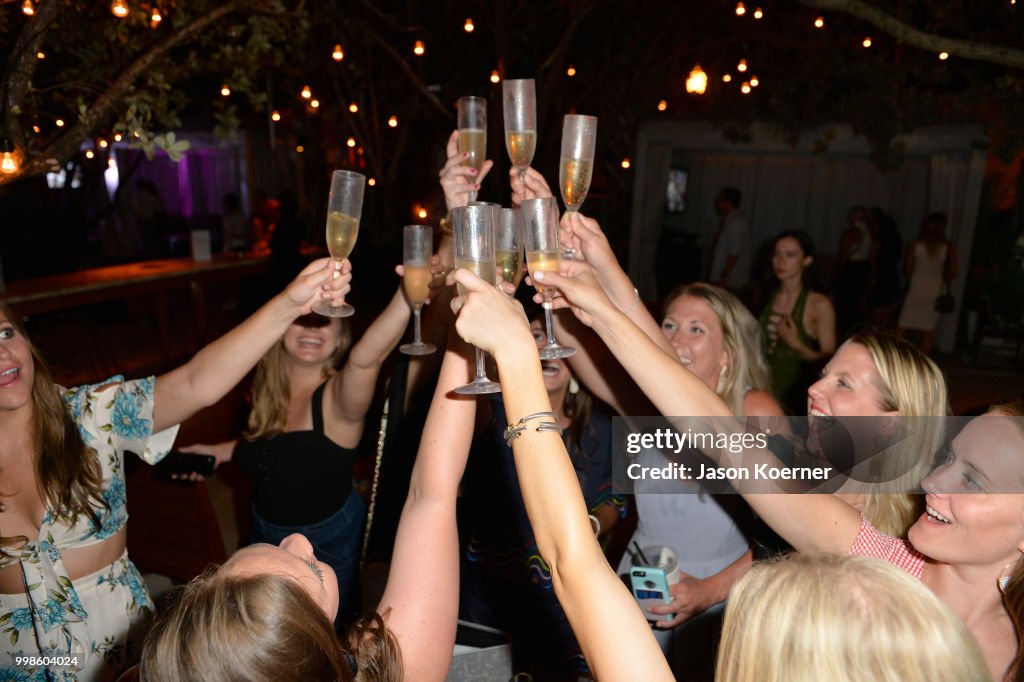 Guests raise a glass during the Monica Hansen Beachwear Party At Hyde