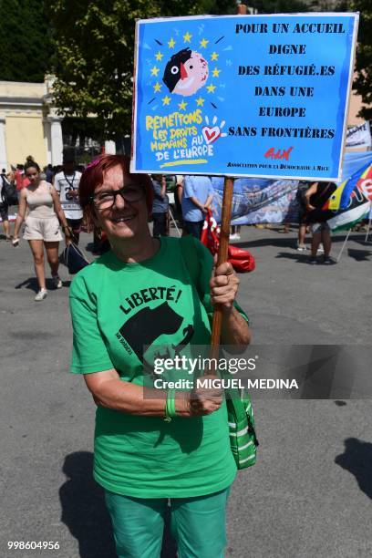 Woman holds a board reading "For a dignified welcome for refugees in an Europe without borders" during a demonstration at the call of an Italian...