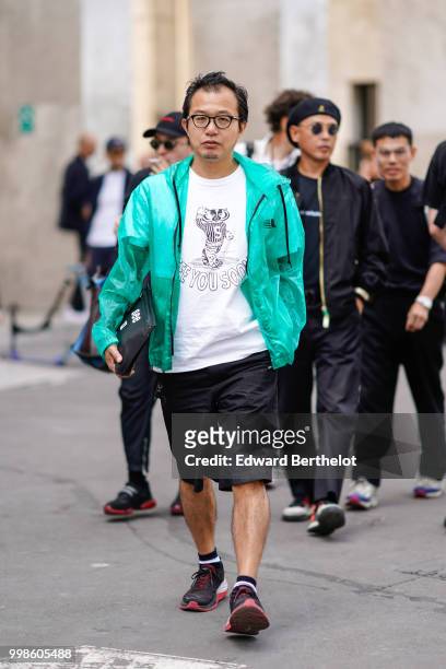 Guest wears a green jacket, a white t-shirt, black shorts, sneakers, outside Lanvin, during Paris Fashion Week - Menswear Spring-Summer 2019, on June...