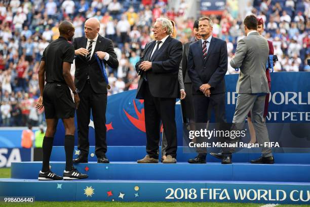 President Gianni Infantino awards Fourth official Malang Diedhiou during medal ceremony following the 2018 FIFA World Cup Russia 3rd Place Playoff...