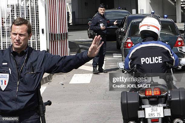 Policemen direct the police convoy with the car carrying Iranian agent Ali Vakili Rad, upon its arrival at the Orly airport, near Paris, on May 18,...